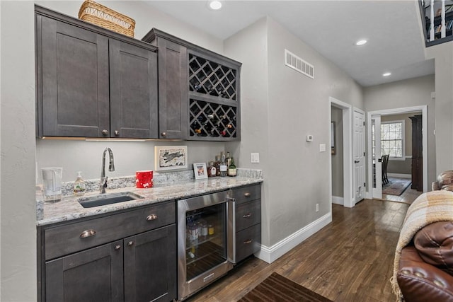 bar with a sink, baseboards, wine cooler, indoor bar, and dark wood-style floors