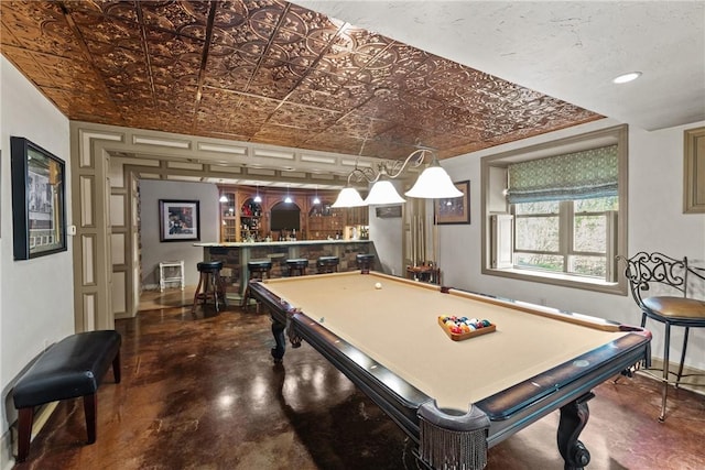 recreation room featuring indoor bar, billiards, finished concrete flooring, and an ornate ceiling