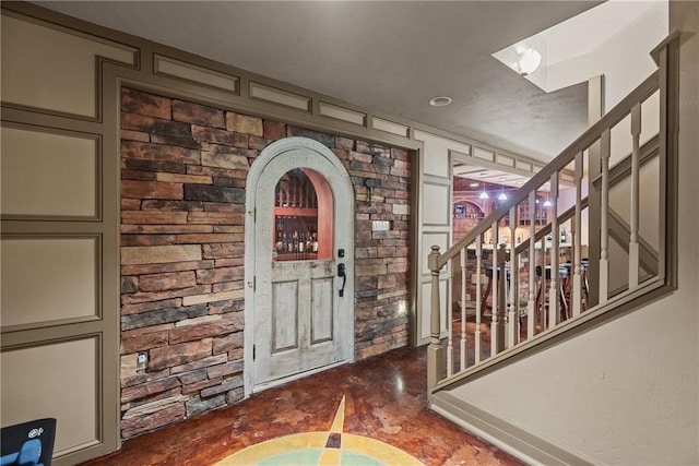entrance foyer featuring stairway and concrete floors