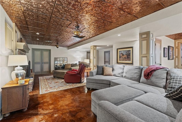 living area with ceiling fan, an ornate ceiling, ornate columns, recessed lighting, and concrete floors