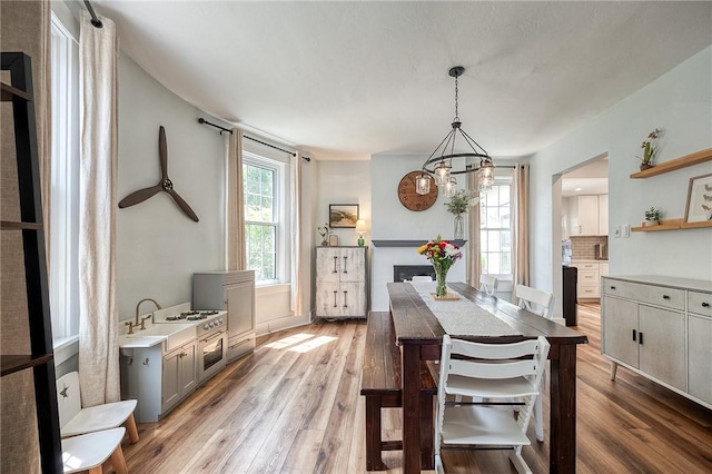 dining area with light wood-style floors and a notable chandelier