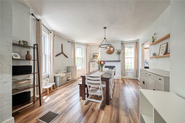 dining room featuring visible vents, an inviting chandelier, and light wood-style floors