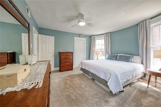 bedroom with a ceiling fan, multiple windows, carpet, and a closet