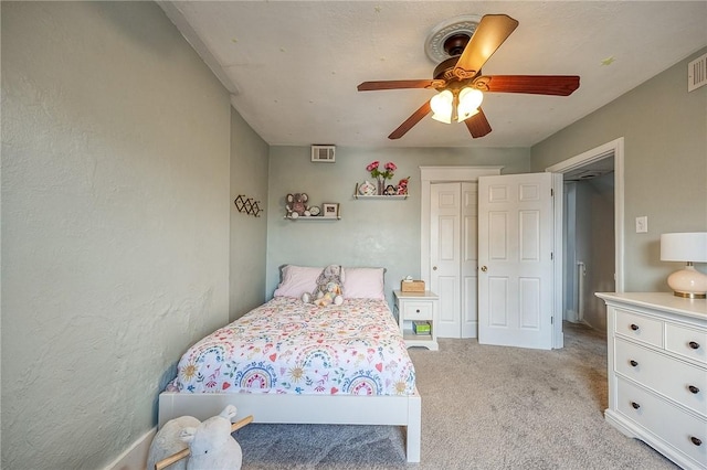 bedroom with a closet, light carpet, a ceiling fan, and visible vents