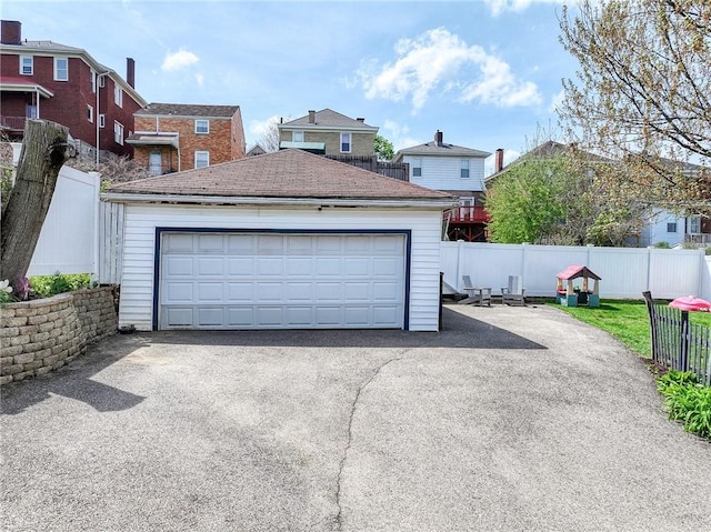 detached garage featuring fence