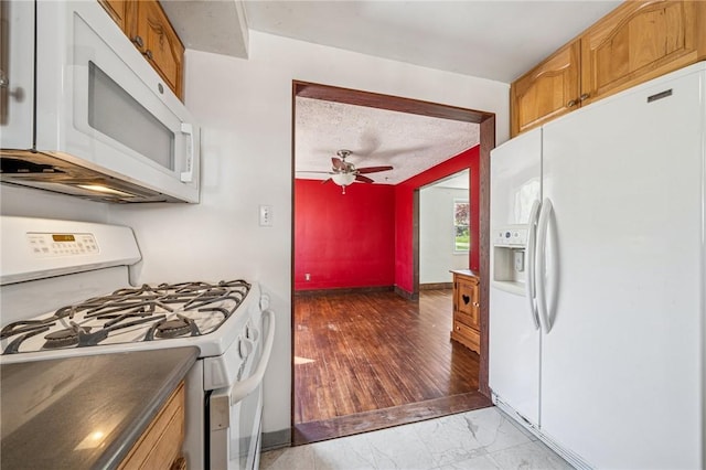 kitchen with marble finish floor, white appliances, baseboards, ceiling fan, and brown cabinets