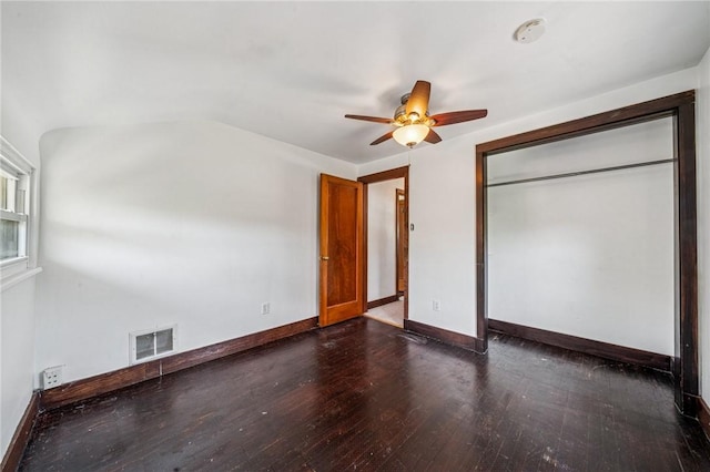 unfurnished bedroom featuring visible vents, baseboards, dark wood-type flooring, and ceiling fan