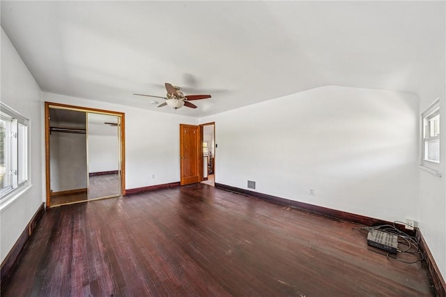 unfurnished bedroom with visible vents, dark wood finished floors, baseboards, and multiple windows