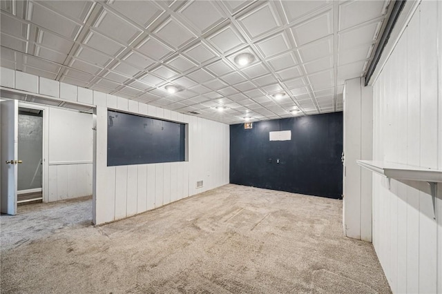 finished basement featuring wood walls and carpet