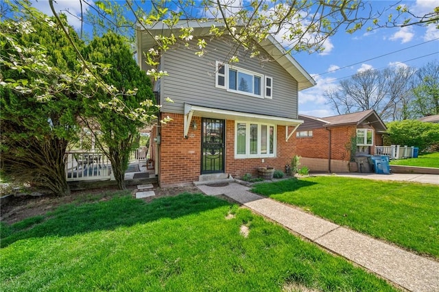 view of front facade with a porch, brick siding, and a front yard
