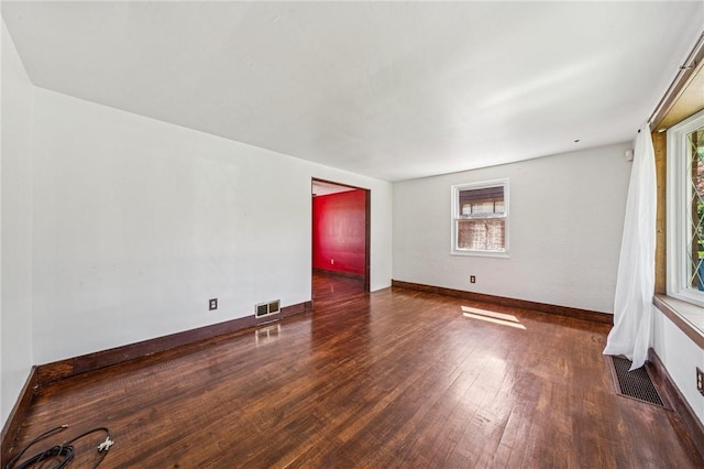 unfurnished room featuring visible vents, baseboards, and wood finished floors