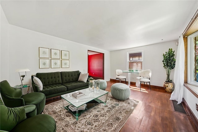 living room featuring visible vents, baseboards, and wood finished floors