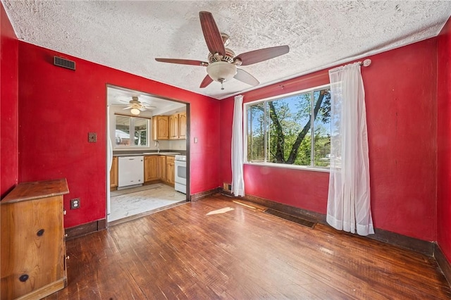 empty room featuring ceiling fan, visible vents, a sink, baseboards, and light wood-style floors