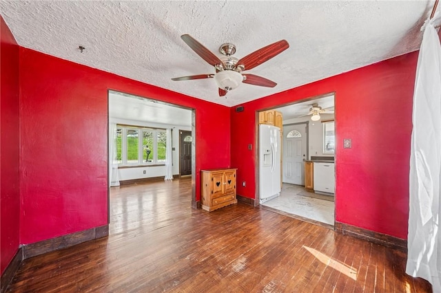 spare room featuring a ceiling fan, baseboards, hardwood / wood-style flooring, and a textured ceiling