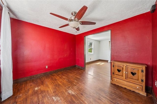 empty room featuring baseboards, a textured ceiling, ceiling fan, and hardwood / wood-style floors