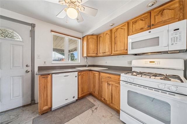 kitchen with a ceiling fan, dark countertops, a sink, marble finish floor, and white appliances
