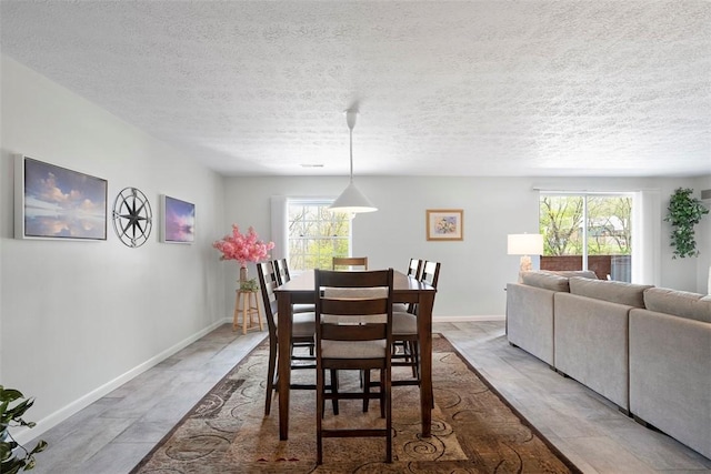 dining area with baseboards and a textured ceiling