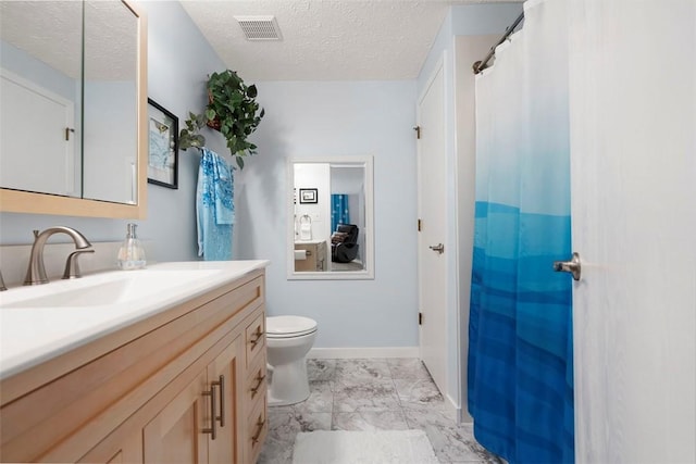 bathroom with vanity, toilet, a textured ceiling, marble finish floor, and visible vents
