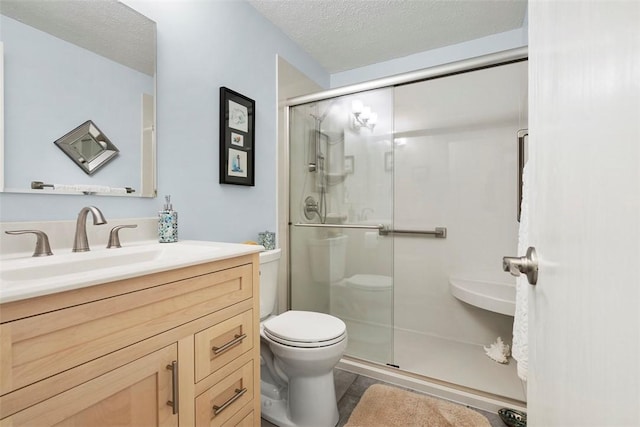 full bath featuring vanity, toilet, a textured ceiling, a shower stall, and wood finished floors