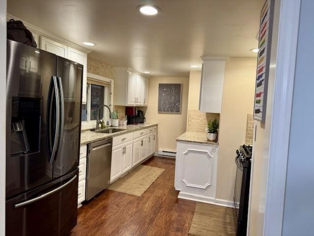 kitchen featuring a sink, appliances with stainless steel finishes, a baseboard heating unit, and white cabinets