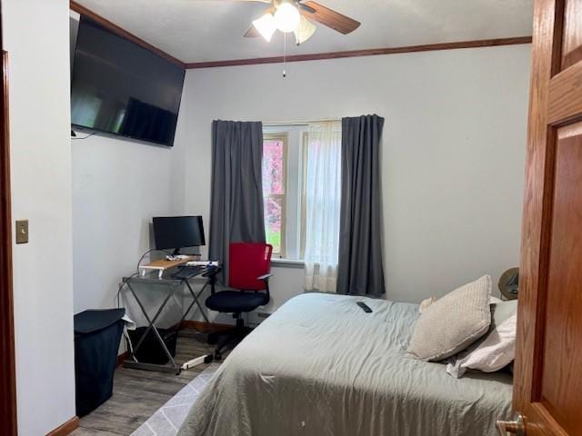 bedroom with crown molding, baseboards, ceiling fan, and wood finished floors