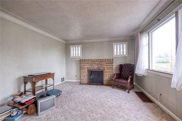 sitting room with crown molding, a textured ceiling, visible vents, and a stone fireplace