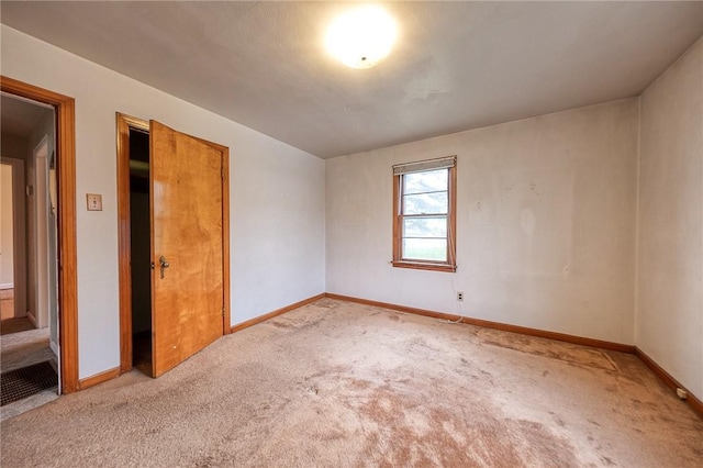 unfurnished room featuring carpet floors and baseboards