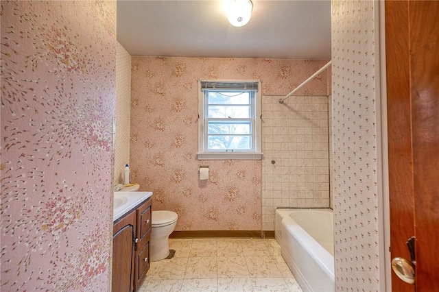 bathroom with vanity, bathing tub / shower combination, toilet, baseboards, and wallpapered walls