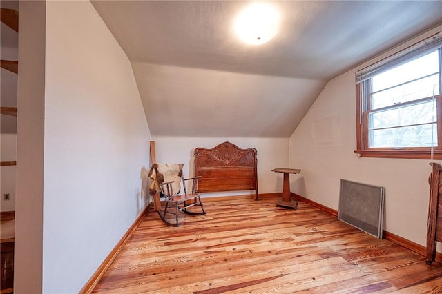 sitting room featuring light wood-style floors, baseboards, and lofted ceiling