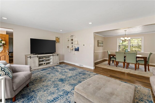 living area with baseboards, recessed lighting, wood finished floors, and a chandelier