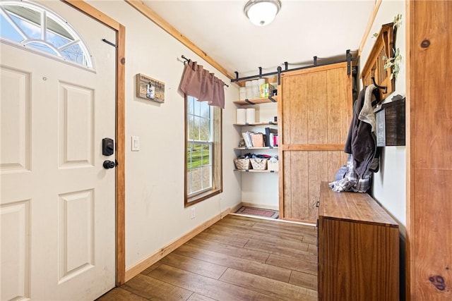foyer entrance featuring baseboards and hardwood / wood-style floors