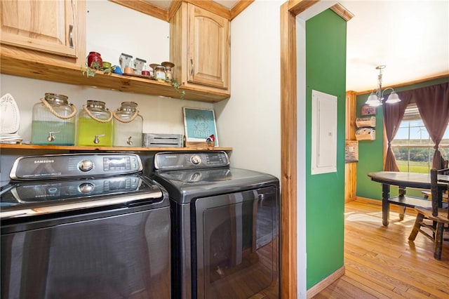 laundry area featuring washer and dryer, cabinet space, light wood-style flooring, baseboards, and electric panel