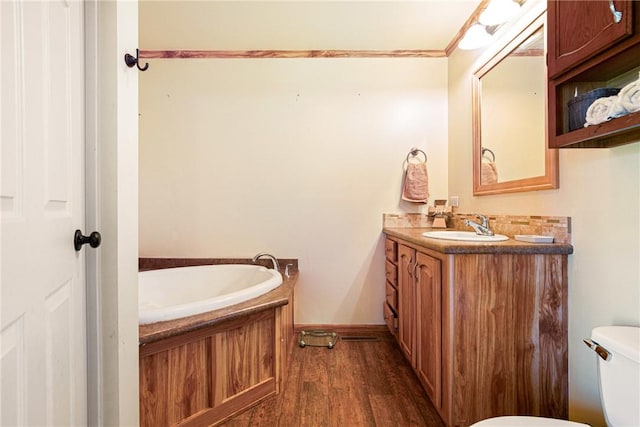 full bath featuring vanity, a garden tub, wood finished floors, and toilet