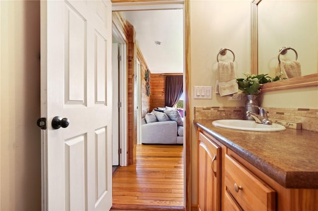 bathroom with decorative backsplash, wood finished floors, and vanity