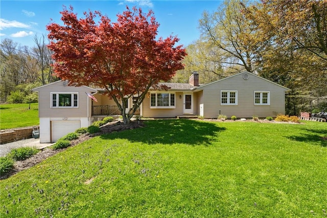 view of front facade with an attached garage, a front yard, driveway, and a chimney
