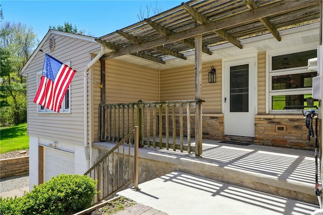 view of patio / terrace featuring an attached garage, a pergola, and covered porch