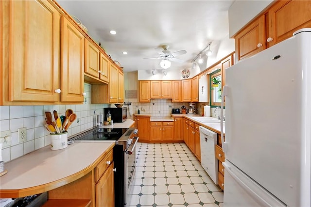 kitchen featuring light countertops, a sink, ceiling fan, and white appliances