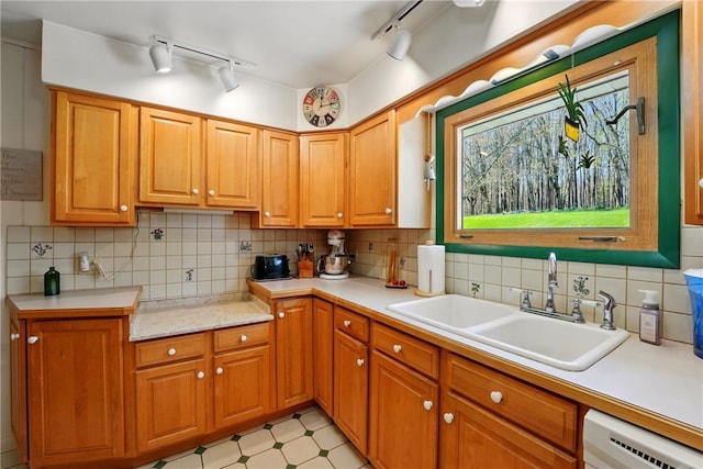 kitchen featuring decorative backsplash, light floors, light countertops, a sink, and dishwasher