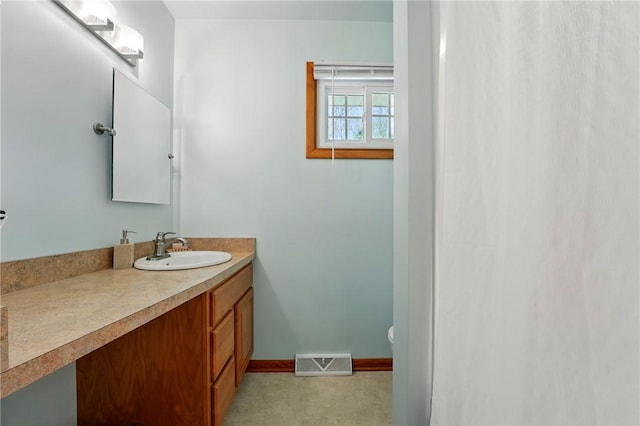 bathroom featuring visible vents, baseboards, and vanity