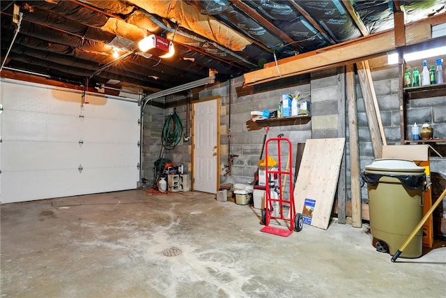 garage featuring a garage door opener and concrete block wall