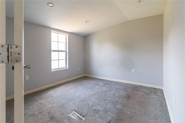 empty room featuring vaulted ceiling, baseboards, carpet flooring, and visible vents