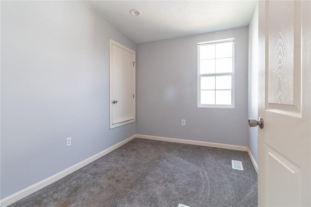 unfurnished room with carpet flooring and baseboards