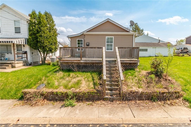 back of property featuring a yard, a deck, and stairs