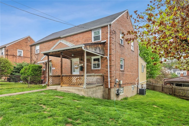 back of house with fence, cooling unit, brick siding, a lawn, and a porch