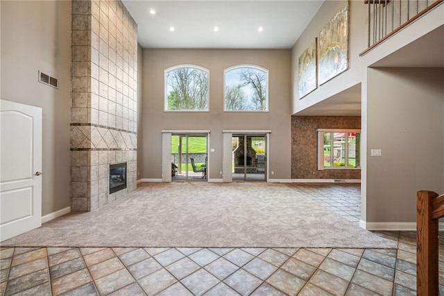 127 Bridle Trl, Peters Twp, PA 15367 - unfurnished living room featuring carpet floors, plenty of natural light, a tiled fireplace, a towering ceiling, and visible vents