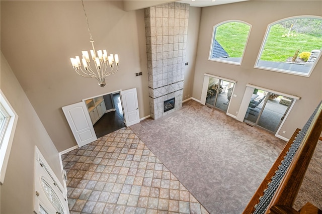 127 Bridle Trl, Peters Twp, PA 15367 - foyer entrance featuring a fireplace, baseboards, a high ceiling, carpet, and a notable chandelier
