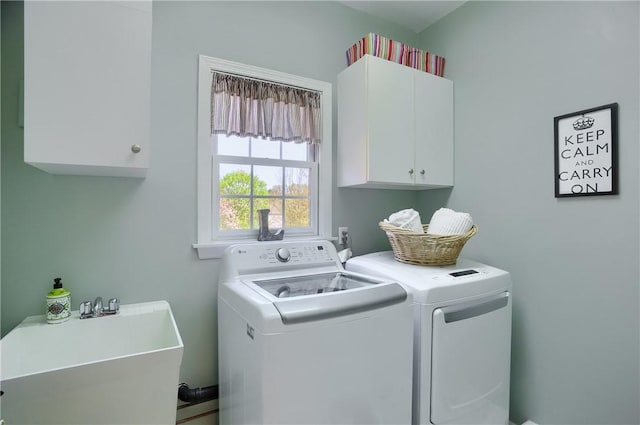 washroom with a sink, cabinet space, and washing machine and clothes dryer
