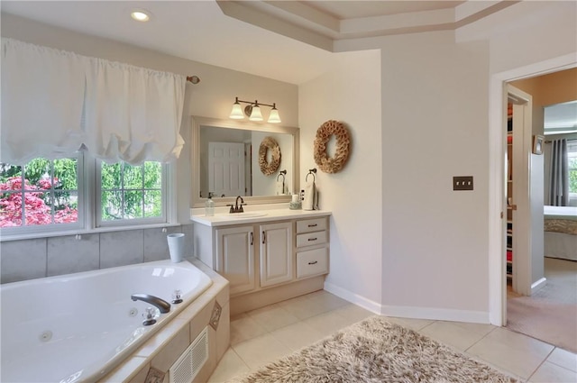 bathroom featuring a jetted tub, tile patterned floors, baseboards, vanity, and ensuite bath