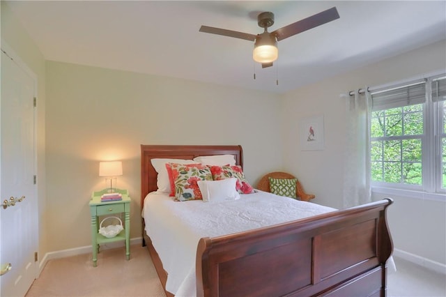 bedroom with baseboards, a ceiling fan, and light colored carpet