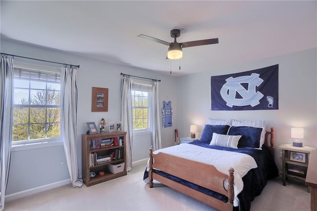 bedroom with baseboards, a ceiling fan, and light carpet